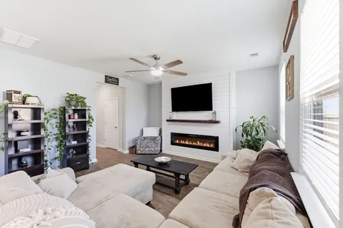 Living room with a white shiplap fireplace wall, floating wood mantel, and linear electric fireplace