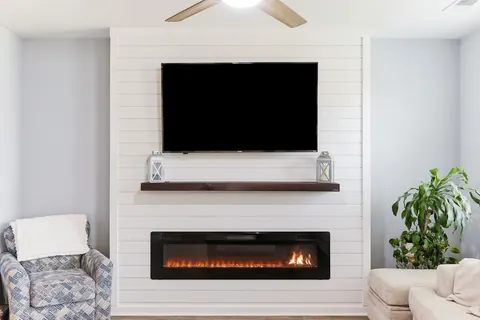 Close view of the electric fireplace and shiplap TV wall