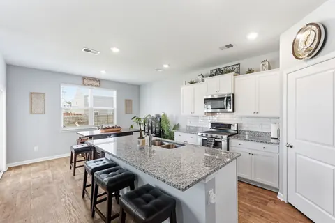Kitchen with a granite island and white shaker-style cabinets
